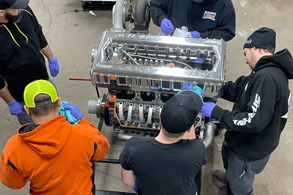 diesel performance upgrades, diesel repair in Bremen, OH at Unlimited Diesel Performance. Team assembling a high-performance engine at an auto shop, focusing on precision and collaboration.