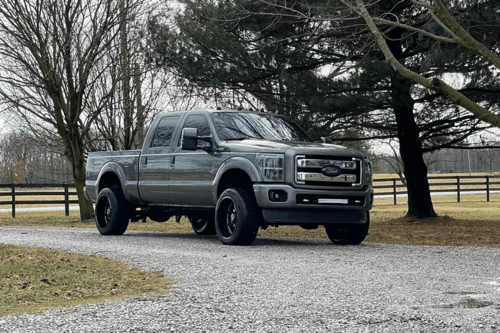 Expert Diesel Repair tips from Unlimited Diesel in Bremen, OH. Image of gray ford powerstroke diesel truck parked near a farm fence.