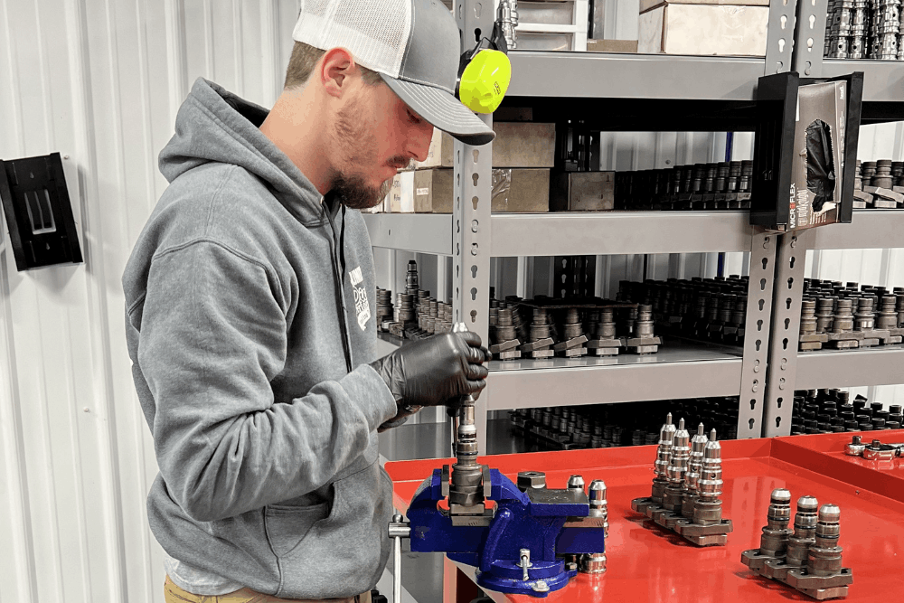 Diesel injector service, diesel repair in Bremen, OH by Unlimited Diesel Performance. Image of a technician rebuilding a diesel fuel injector at a workbench during precision engine component repair.