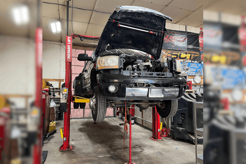 Diesel repair in Bremen, OH by Unlimited Diesel Performance. Image of a diesel truck lifted in a professional repair shop with the hood open for diagnostics and engine service, highlighting expert diesel maintenance and performance-focused repairs.